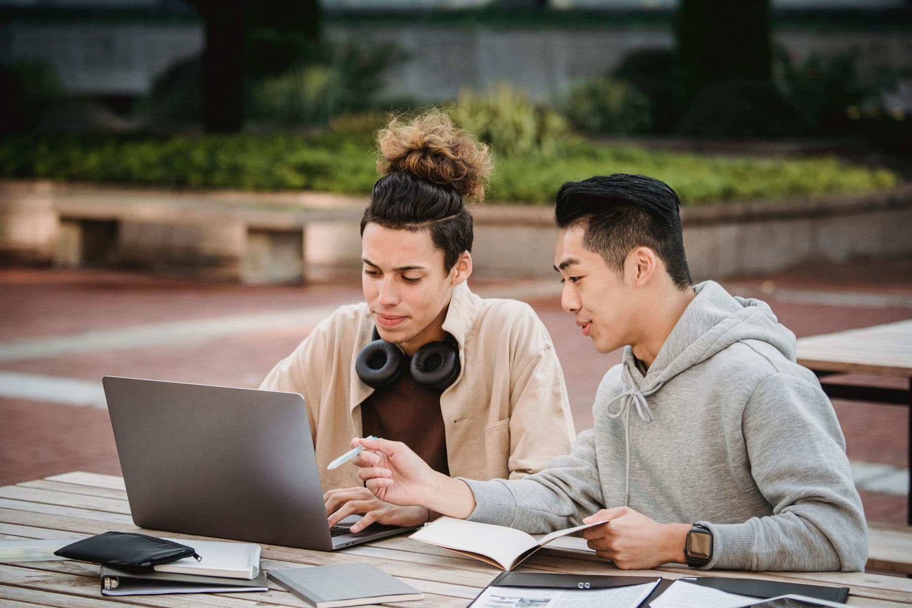 Two students working through a project brief at a campus bench